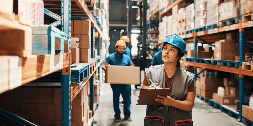 Woman in hard hat takes inventory in a factory