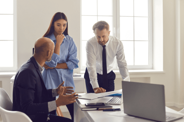 3 colleagues discussing work in an office