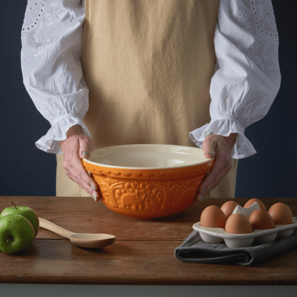 Woman holding a bowl next to 6 eggs